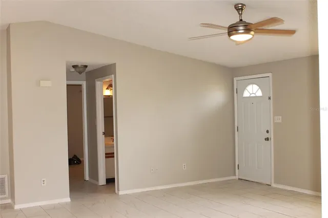 a view of a hallway with a chandelier fan