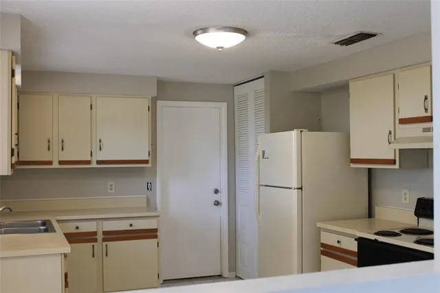 a kitchen with stainless steel appliances a refrigerator and cabinets