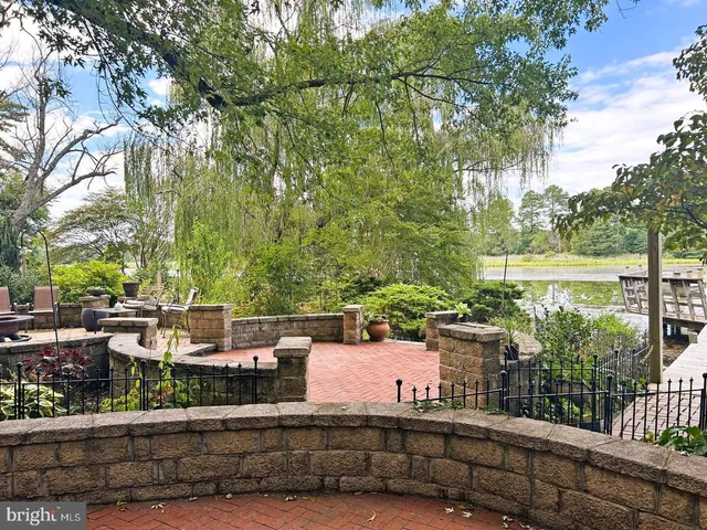 a view of a lake with outdoor seating and trees