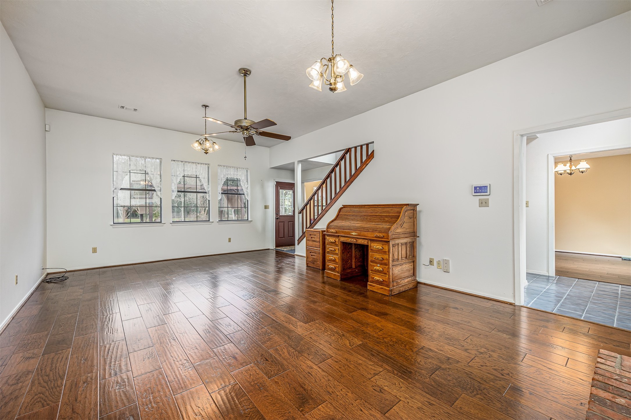 329 Burwell Road Highlands, TX 77562 - Photo 15 of 44 a view of an empty room with wooden floor staircase and a kitchen