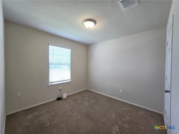 an empty room with a window and a sink