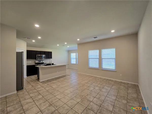 a large space with a large window and stainless steel appliances