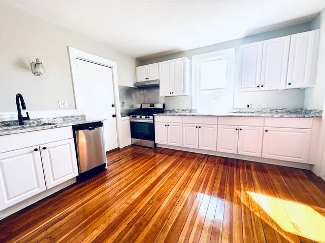 a kitchen with wooden floors and appliances