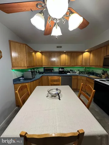 a large white kitchen with a large island in the center