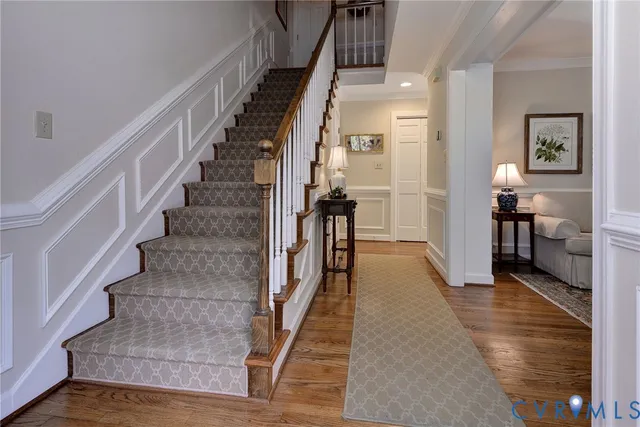 a view of a hallway with wooden floor and stairs