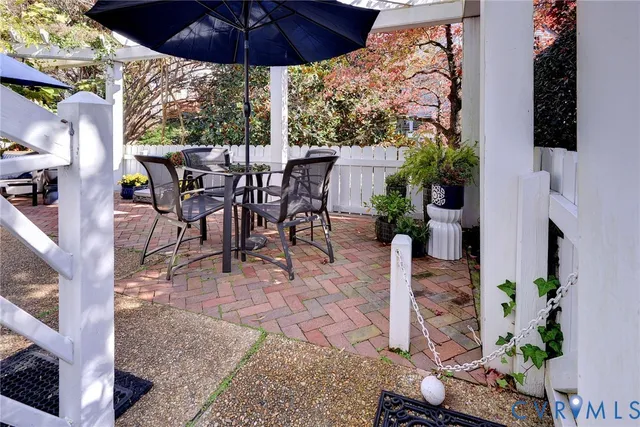 a view of a patio with table and chairs under an umbrella