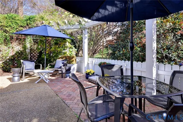 a view of a patio with a table and chairs under an umbrella