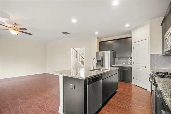 a kitchen with stainless steel appliances granite countertop a stove a sink and a refrigerator