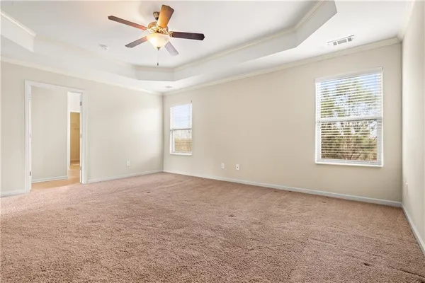 an empty room with windows and fan