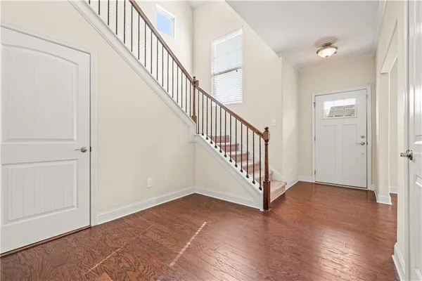 a view of a hallway with wooden floor and stairs