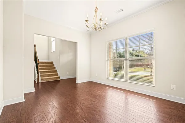 a view of a livingroom with wooden floor and a ceiling fan