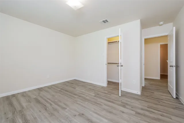 a view of empty room with wooden floor