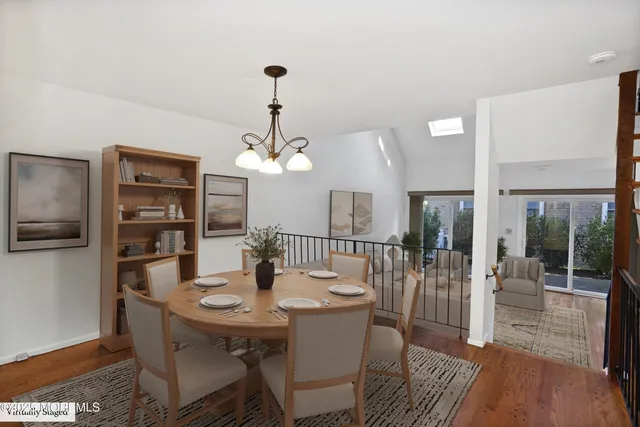 a living room with furniture a flat screen tv and a dining table