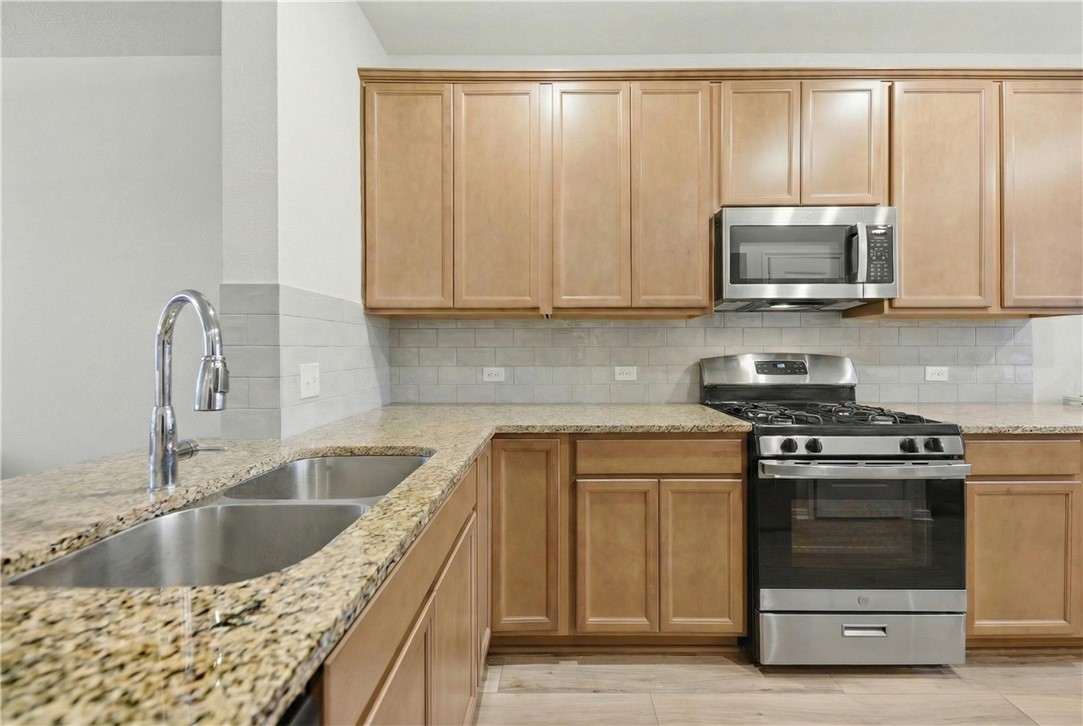 1443 Lk Rdg Drive Brenham, TX 77833 - Photo 4 of 17 a kitchen with granite countertop a sink and a stove top oven