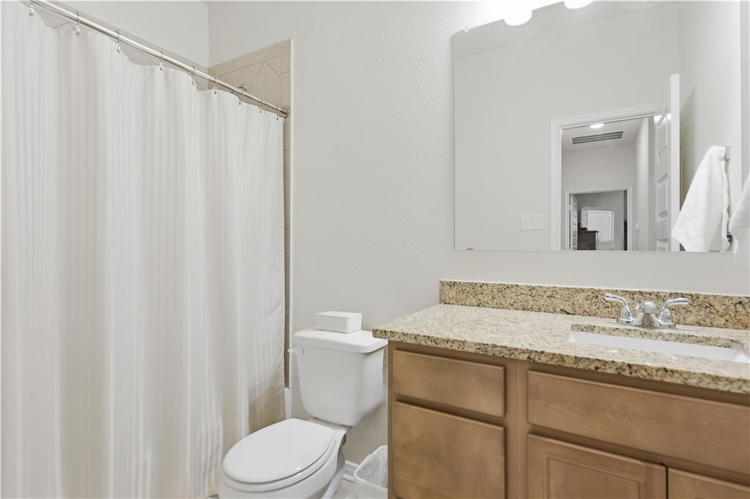 1443 Lk Rdg Drive Brenham, TX 77833 - Photo 10 of 17 a bathroom with a granite countertop sink toilet and mirror
