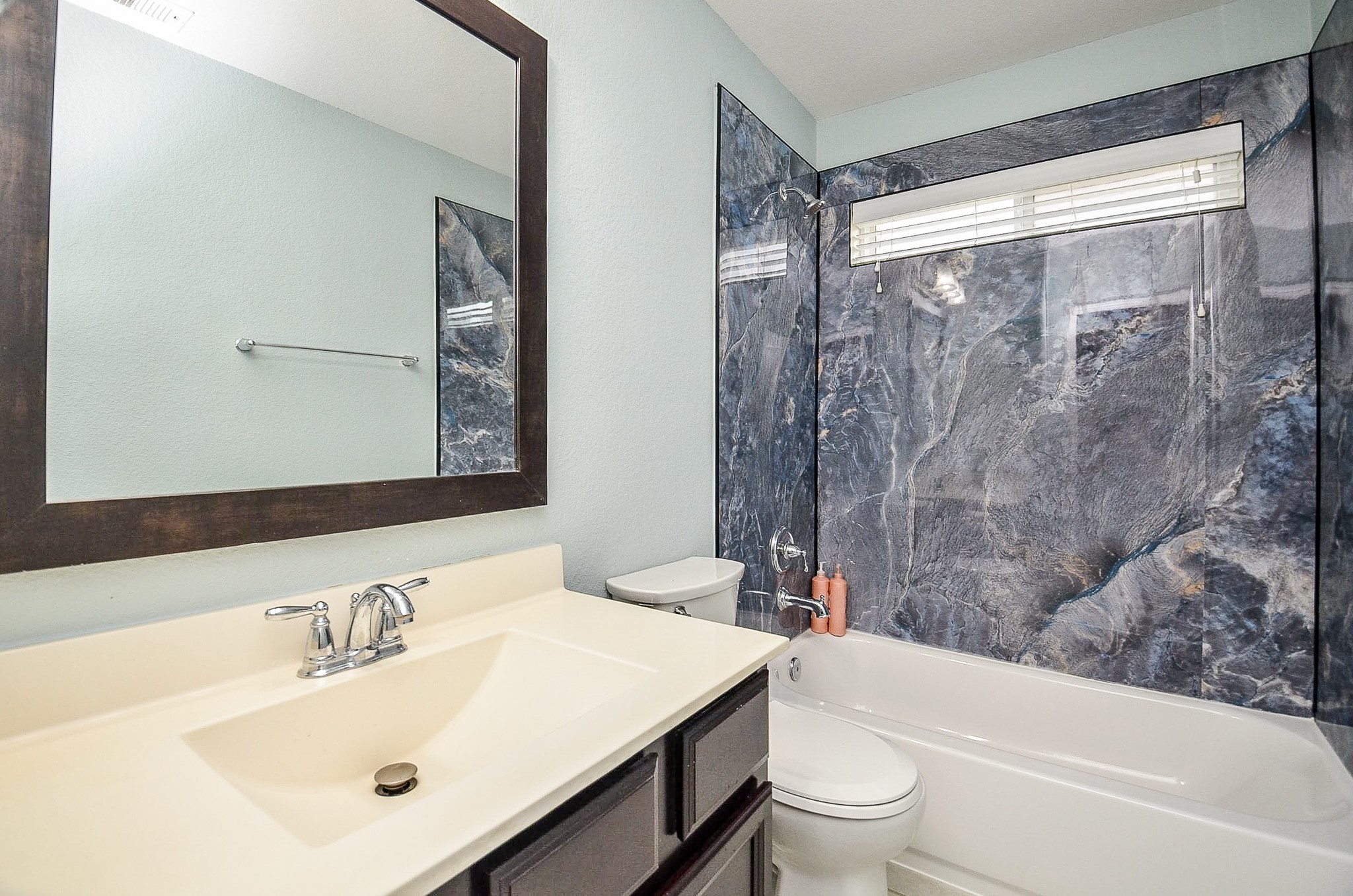 7042 Sliding Rock Circle Spring, TX 77379 - Photo 24 of 36 Discover elegance in Bathroom 4, featuring a chic vanity, a modern tub with stunning marble-style surround, and ample natural light. Perfect for relaxation.