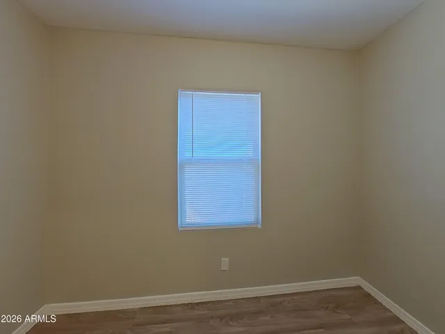 an empty room with wooden floor and closet