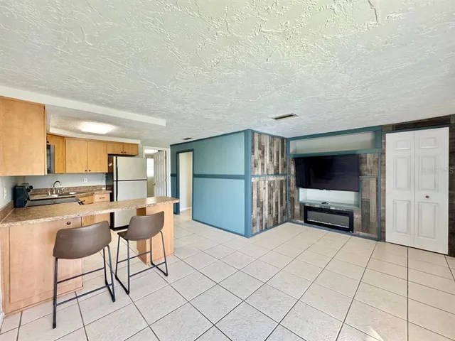 a kitchen with kitchen island a stove a table and chairs