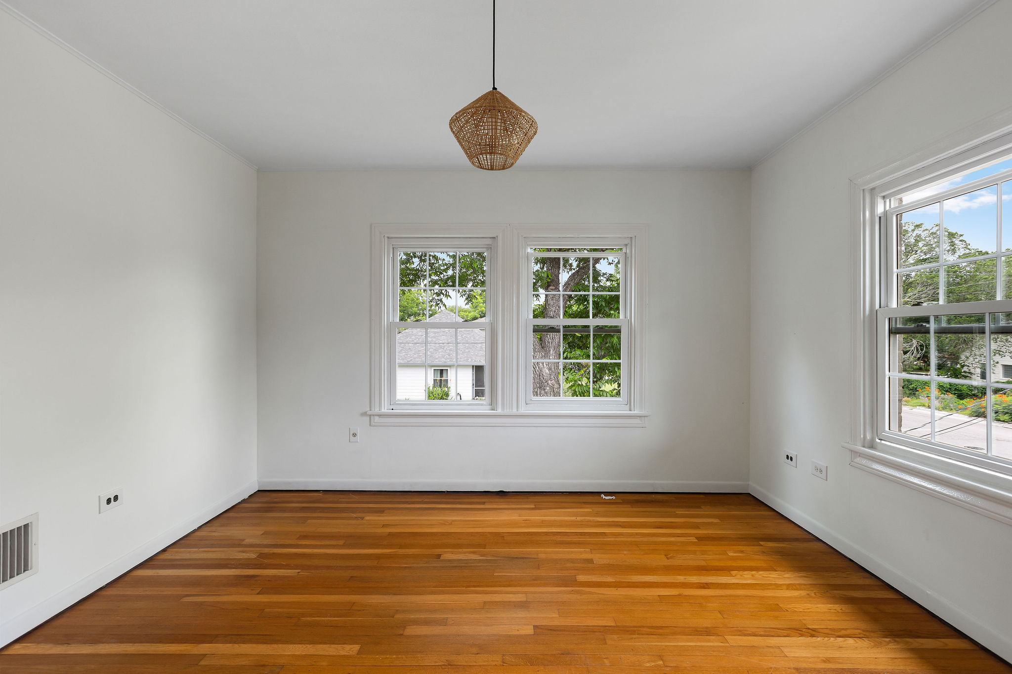 948 Maple Street Lockhart, TX 78644 - Photo 25 of 40 Natural light pours into this room, highlighting the warm tones of the hardwood flooring and offering inviting tree views.