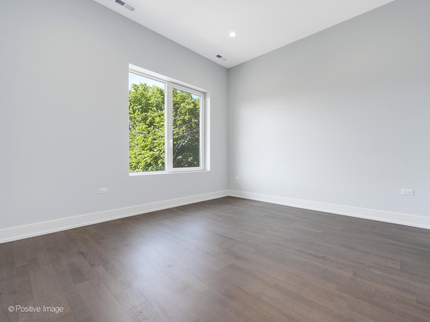 2139 West Madison Street, Unit 212 Chicago, IL 60612 - Photo 6 of 11 an empty room with wooden floor and windows