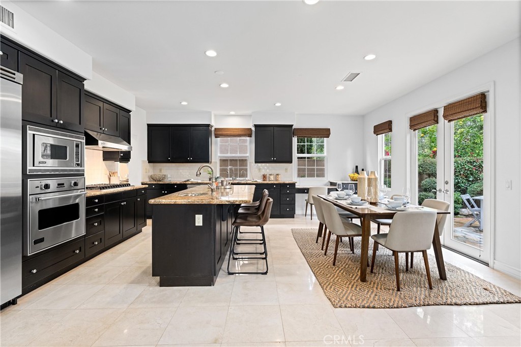 25 Longvale Irvine, CA 92602 - Photo 3 of 58 a kitchen with stainless steel appliances granite countertop a stove a sink a microwave a dining table and chairs