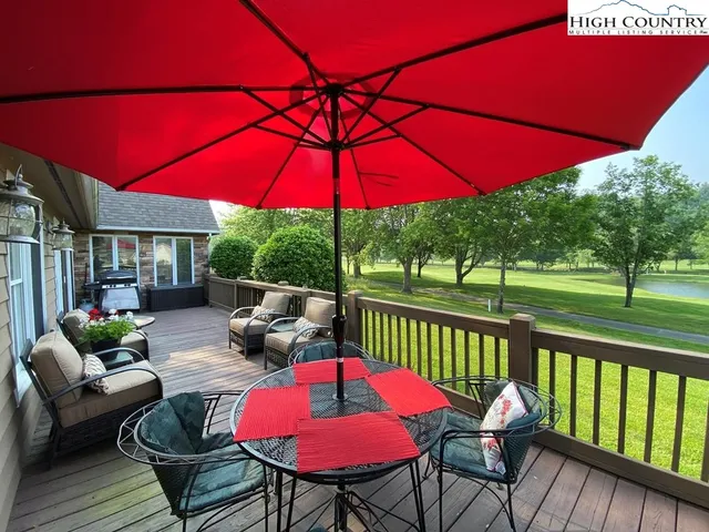 a patio with tables and chairs under an umbrella