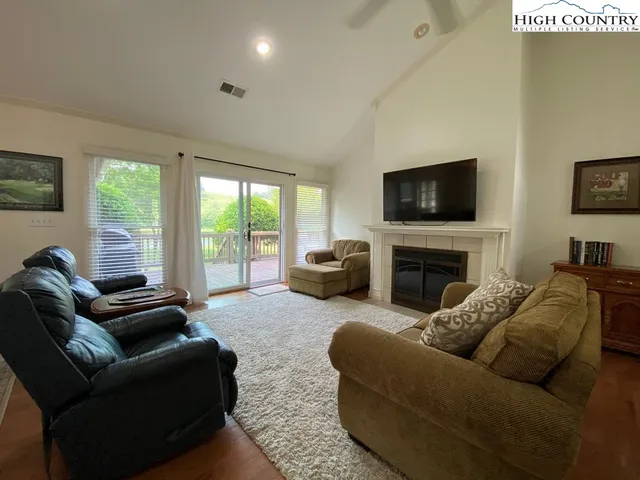 a living room with furniture a fireplace and a flat screen tv
