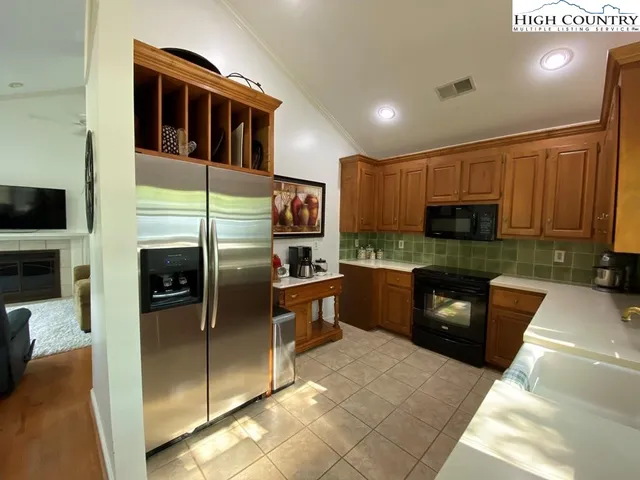 a kitchen with granite countertop a refrigerator and a stove top oven