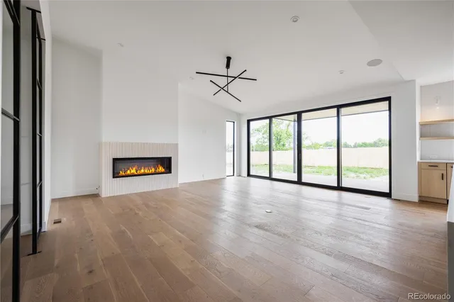 a view of an empty room with a window and a fireplace