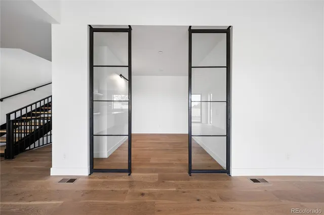 a room with a refrigerator and wooden floor