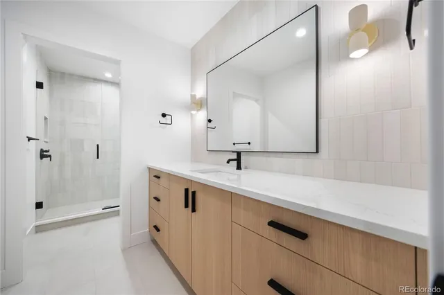 a spacious bathroom with a double vanity sink mirror and shower