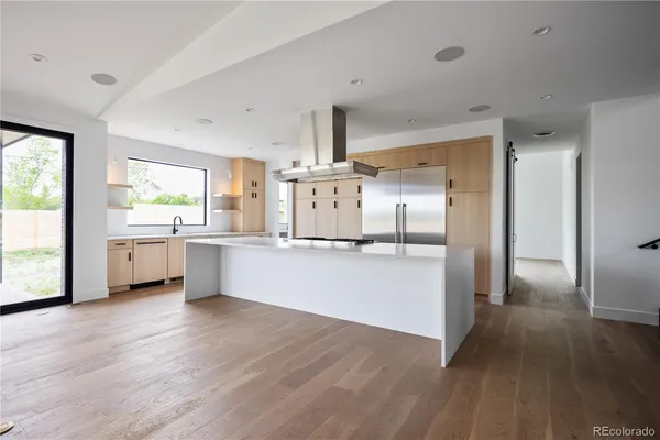 a large kitchen with a wooden floor and a large window