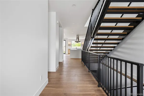 a view of a hallway with wooden floor and staircase