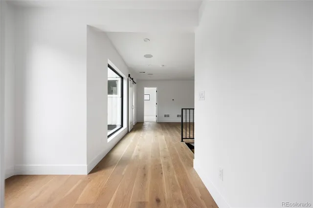 a view of a hallway with wooden floor