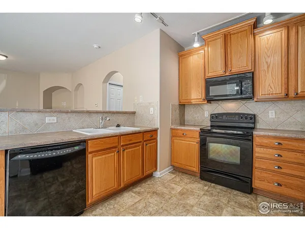 a kitchen with granite countertop a stove top oven microwave and refrigerator