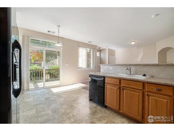 a large white kitchen with granite countertop a sink and a large window