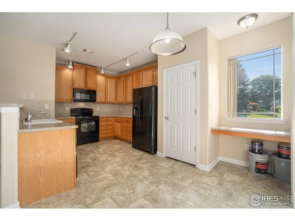 a kitchen with refrigerator cabinets and a sink