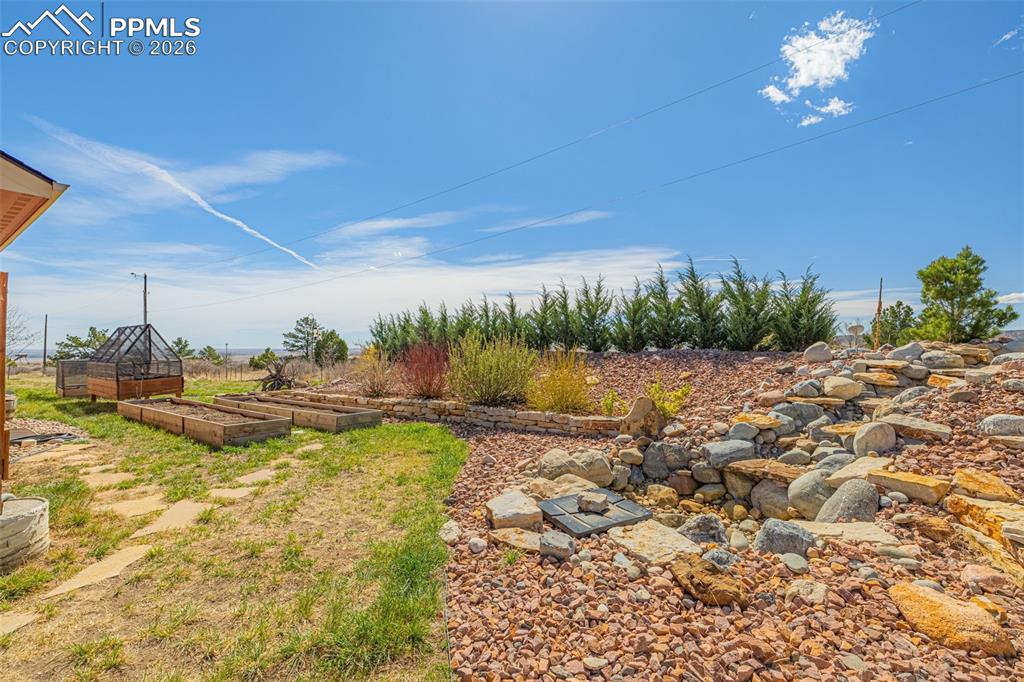 8480 Delaware Road Colorado Springs, CO 80926 - Photo 33 of 49 View of yard with a garden and a water feature