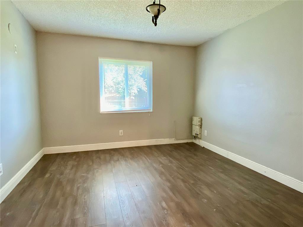 39132 County Road 54, Unit 2230 Zephyrhills, FL 33542 - Photo 12 of 17 an empty room with wooden floor and windows