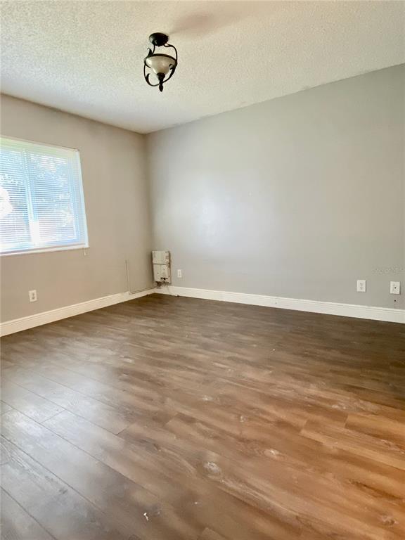 39132 County Road 54, Unit 2230 Zephyrhills, FL 33542 - Photo 13 of 17 an empty room with wooden floor and windows