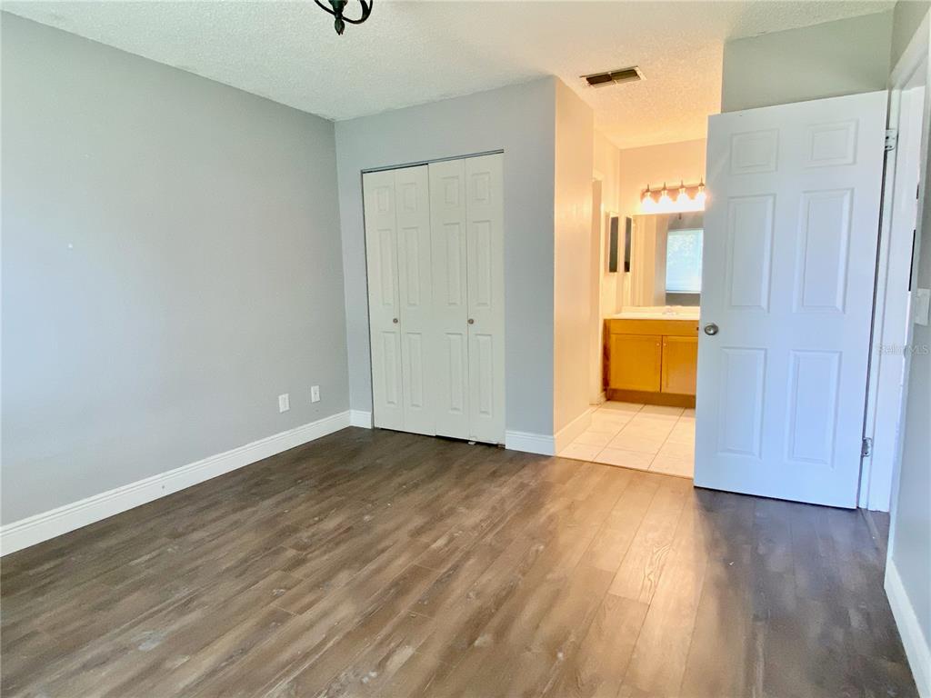 39132 County Road 54, Unit 2230 Zephyrhills, FL 33542 - Photo 14 of 17 a view of an empty room with wooden floor and a bathroom