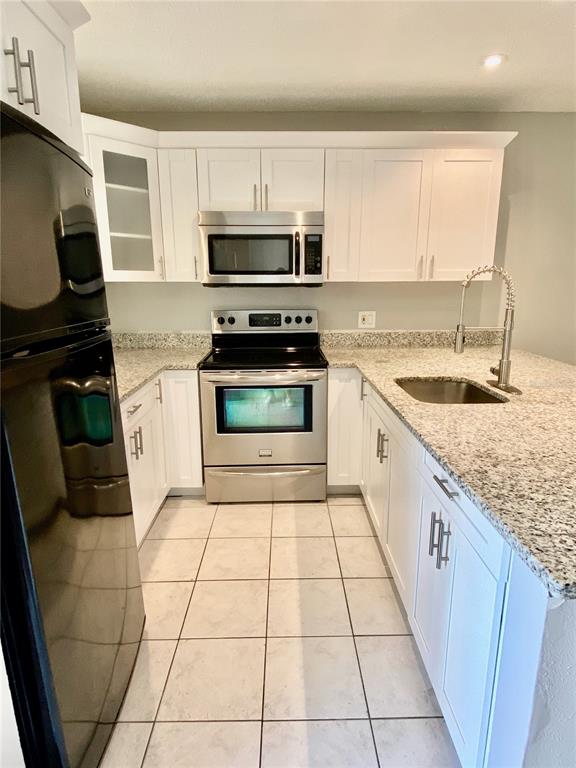 39132 County Road 54, Unit 2230 Zephyrhills, FL 33542 - Photo 5 of 17 a kitchen with a sink a stove top oven and cabinets