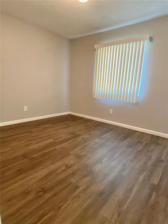 39132 County Road 54, Unit 2230 Zephyrhills, FL 33542 - Photo 10 of 17 a view of an empty room with wooden floor and a window
