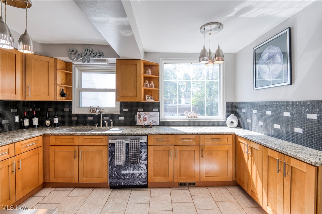 4520 Birchwold Road Cleveland, OH 44121 - Photo 14 of 40 Kitchen featuring pendant lighting, stainless steel range oven, sink, granite countertops, and decorative backsplash