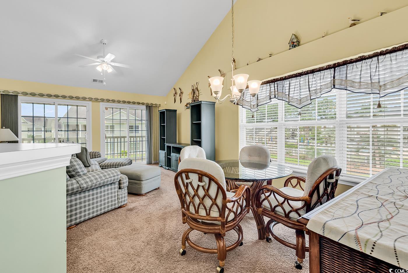 4909 Britewater Court, Unit 202 Myrtle Beach, SC 29579 - Photo 12 of 38 Dining area with light colored carpet, high vaulted ceiling, a chandelier, and ceiling fan