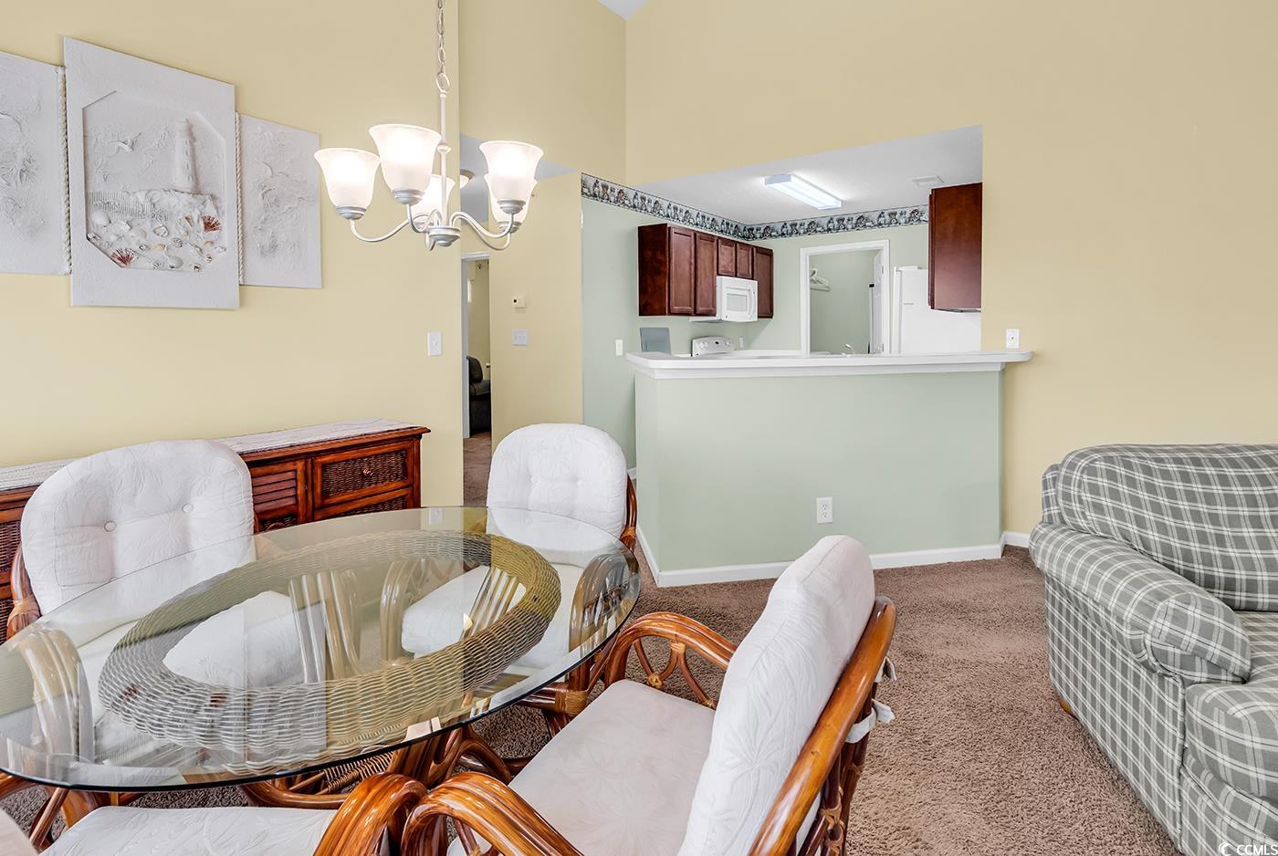 4909 Britewater Court, Unit 202 Myrtle Beach, SC 29579 - Photo 18 of 38 Dining area with carpet floors and a chandelier