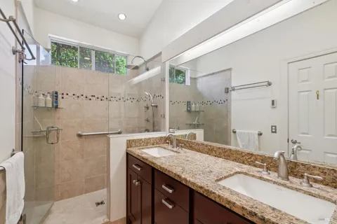 a bathroom with a granite countertop sink and a mirror