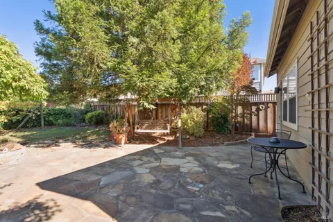 a view of a dinning tables and chairs in backyard of a house