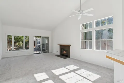 an empty room with windows and fireplace