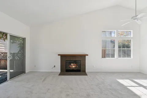 an empty room with windows and fireplace